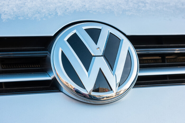 Großaufnahme eines VW-Zeichens an einem Auto