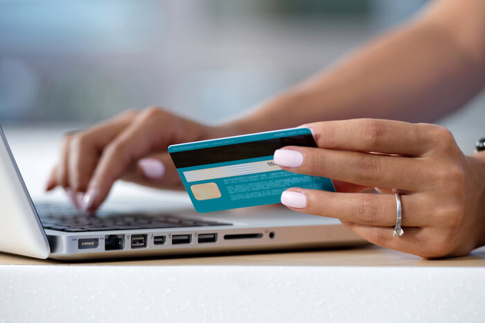 Frau mit Kreditkarte am Laptop