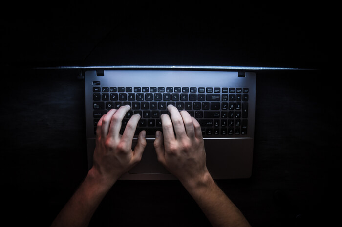 Person sitzt am PC im Dunkeln