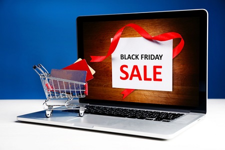 Kreditkarten in einem Einkaufswagen und Laptop, Black Friday Sales Konzept