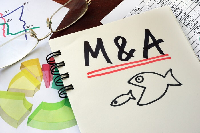 M&A Merger And Acquisitions written on a notepad