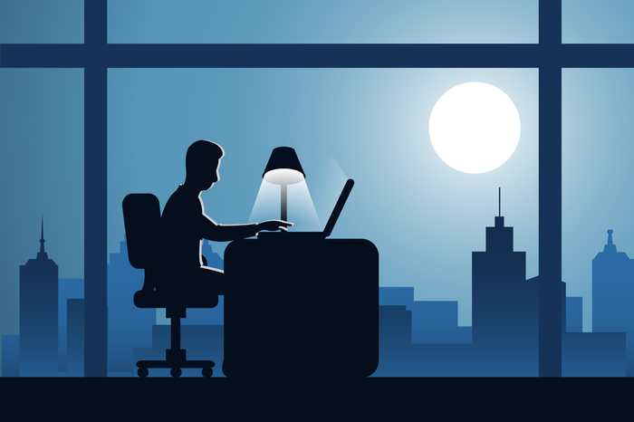 Person sitzt nachts am Schreibtisch
