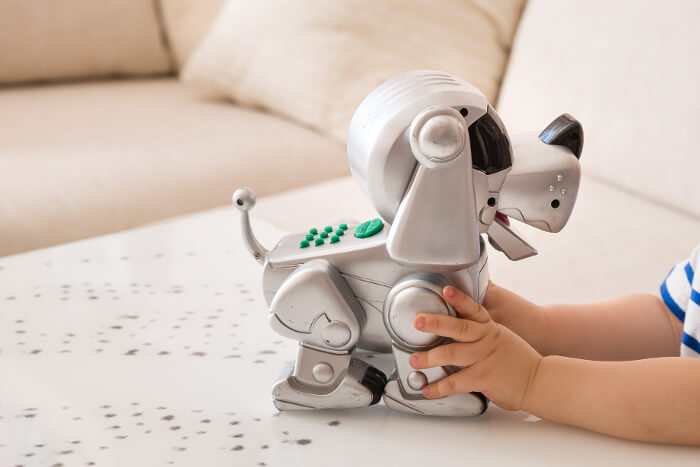 Spielzeug: Kind spielt mit Roboter-Hund
