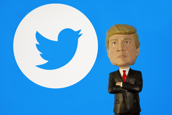 Trump-Figur vor Twitter-Logo