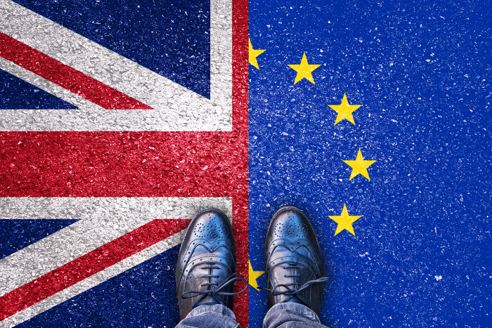 Brexit: Mann steht auf zwei Flaggen: EU und Großbritannien