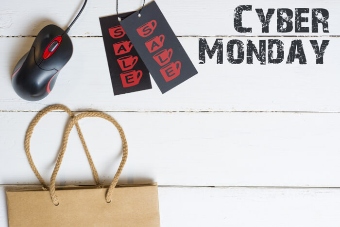 Cyber Monday: Laptop mit Einkaufstüte auf schreibtisch