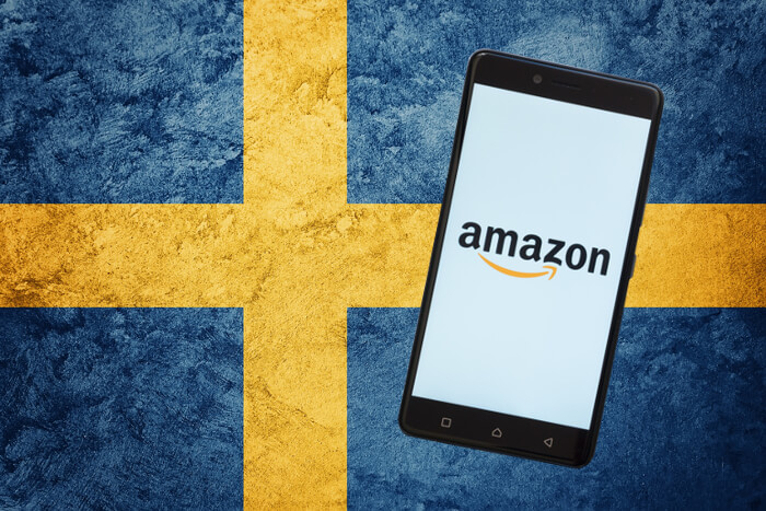 Smartphone mit Amazon-Logo auf schwedischer Flagge