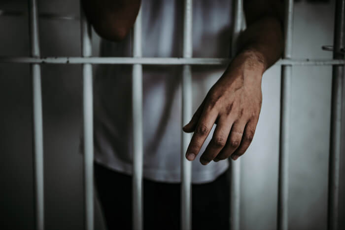Mann in einer Gefängniszelle
