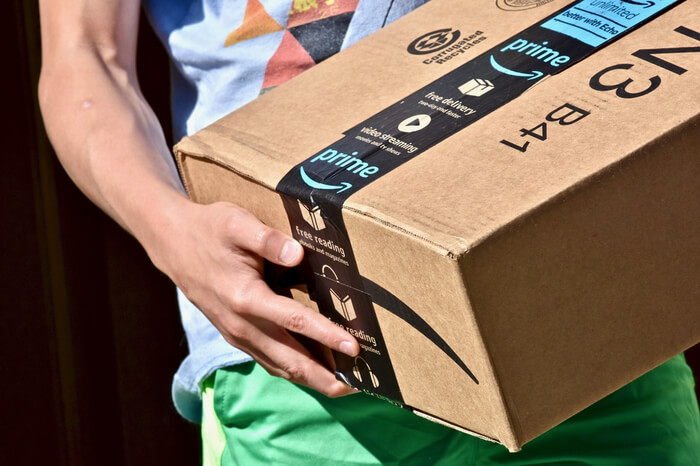 Mann trägt Amazon-Paket