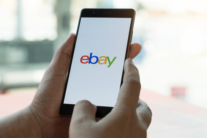 Smartphone, dass auf dem Bildschirm das Ebay Logo anzeigt