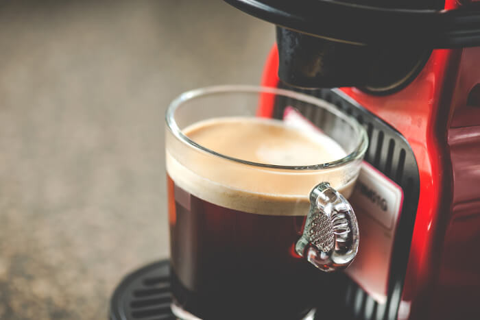 Kaffee, der aus einer Kapselmaschine von Nespresso läuft