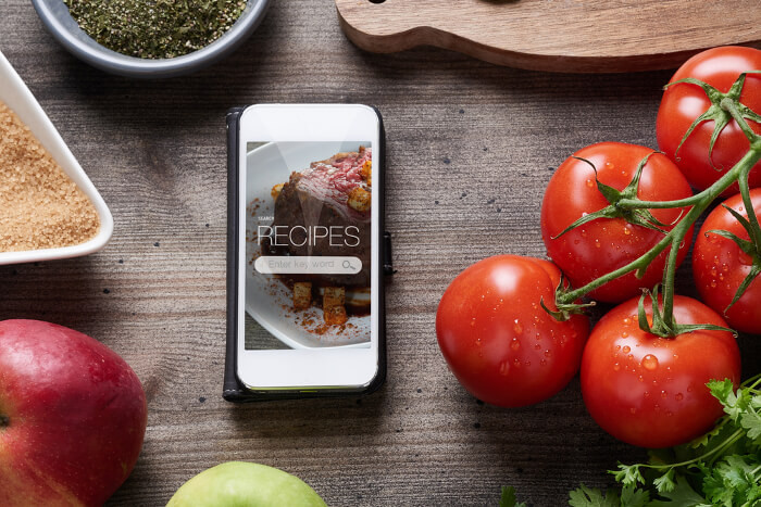 Rezept-Vorschlag auf einem Smartphone: Daneben liegen Lebensmittel