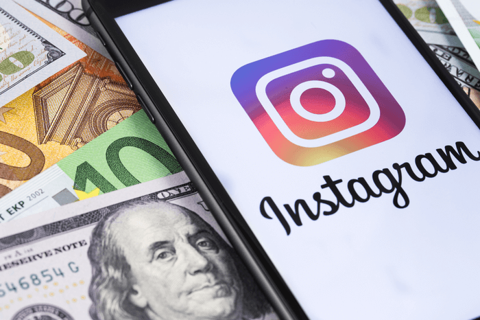 Geld und ein Handy, auf dem die Instagram-App angezeigt wird