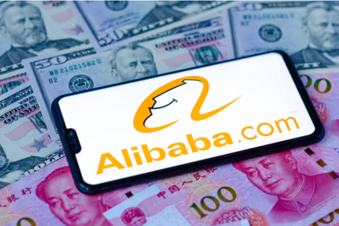 Alibaba auf Smartphone mit Geldscheinen