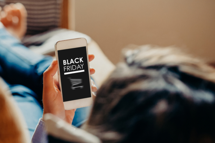 Mann mit Smartphone: Shoppen am Black Friday