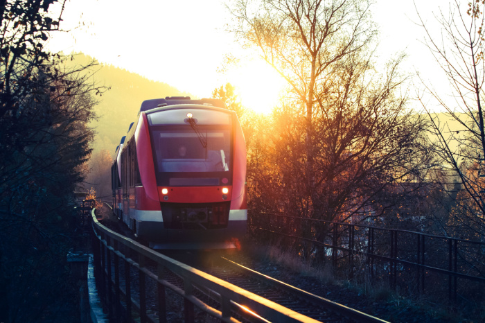 Zug der Deutschen Bahn fährt in den Sonnenuntergang.