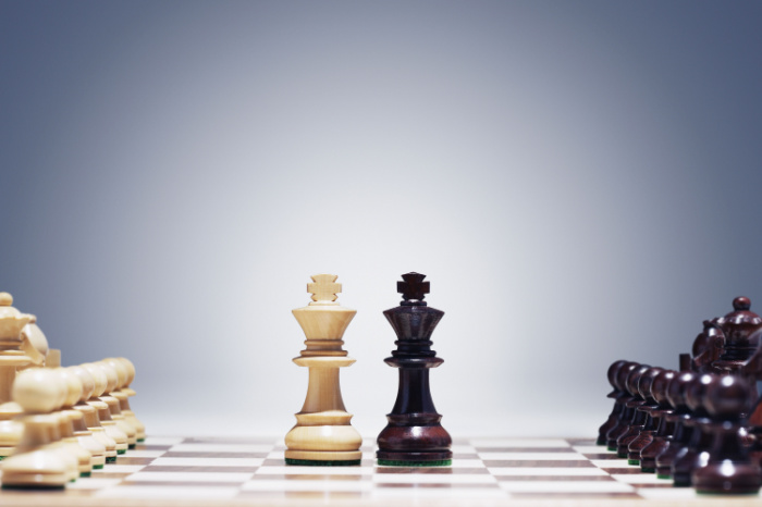 Weißer und schwarzer König auf Schachbrett nebeneinander.