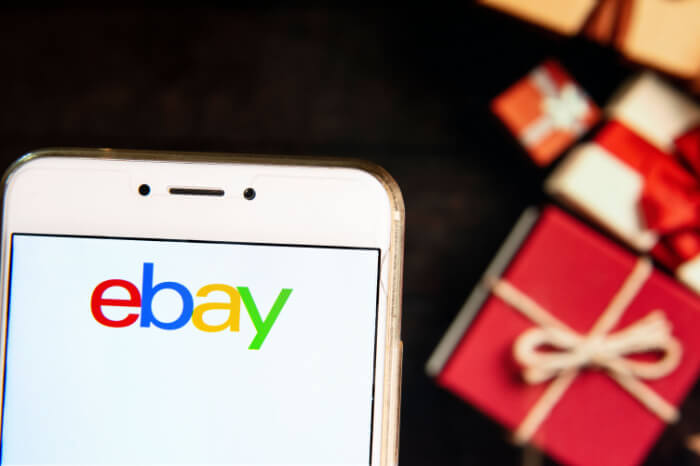 Ebay-Logo auf Smarpthone vor Weihnachtsgeschenken