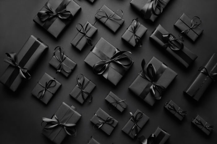 Schwarze Geschenkpäckchen auf schwarzem Grund