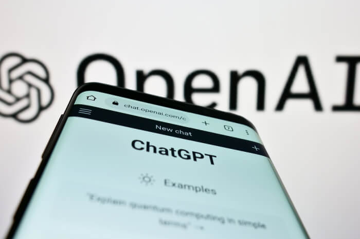 ChatGPT auf Smartphone und OpenAI-Logo im Hintergrund
