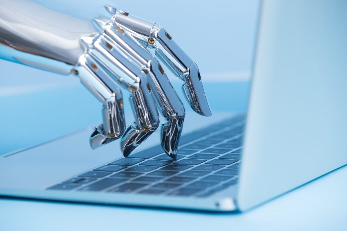 Roboterhand mit Laptop auf blauem Hintergrund