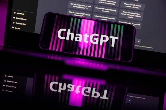 ChatGPT auf Smartphone vor Laptop