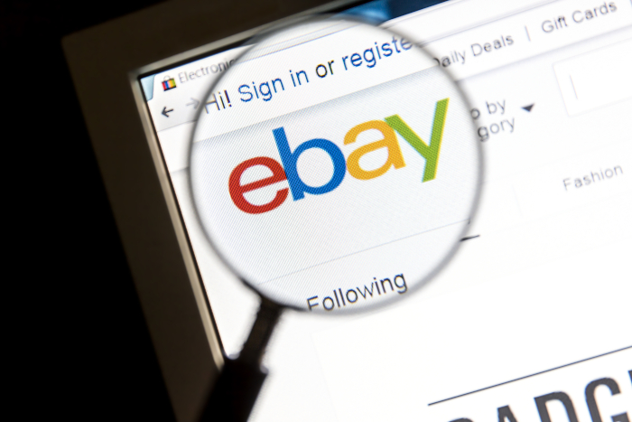 Ebay auf Bildschirm hinter einer Lupe