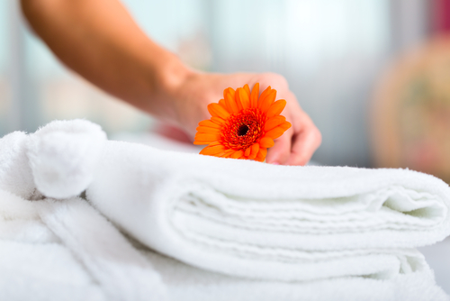 Zimmermädchen legt Blume auf Handtücher