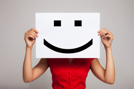 Woman holding a smiling face emoticon
