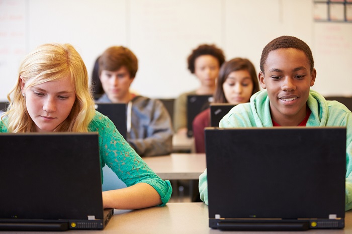 Schüler sitzen am Laptop