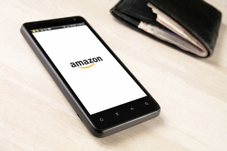 Amazon auf einem Smartphone neben Geldbeutel