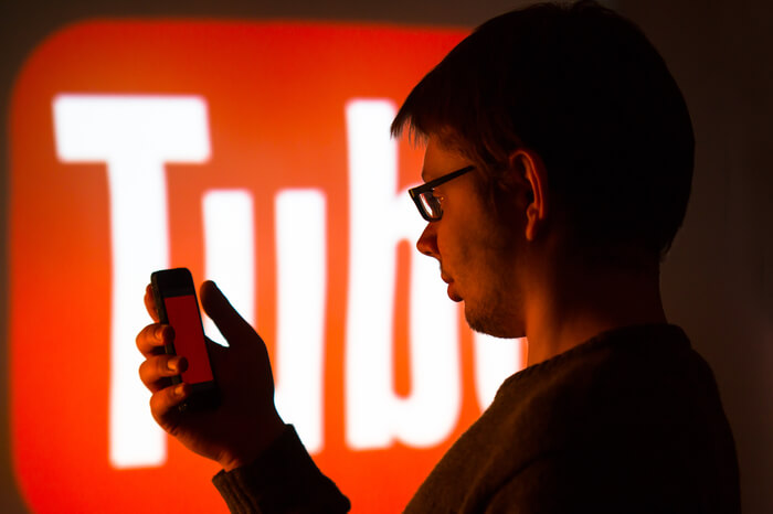 Mann vor YouTube-Logo