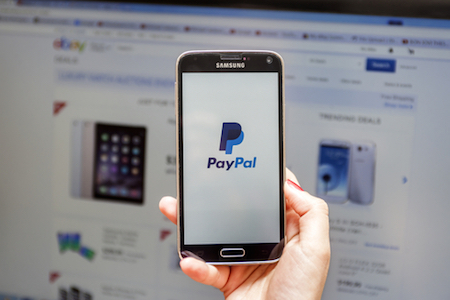 Paypal auf Smartphone vor der Ebay-Website
