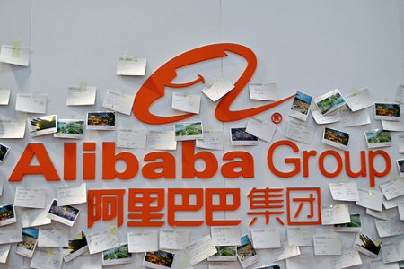 Alibaba Logo an einer Wand mit Postkarten