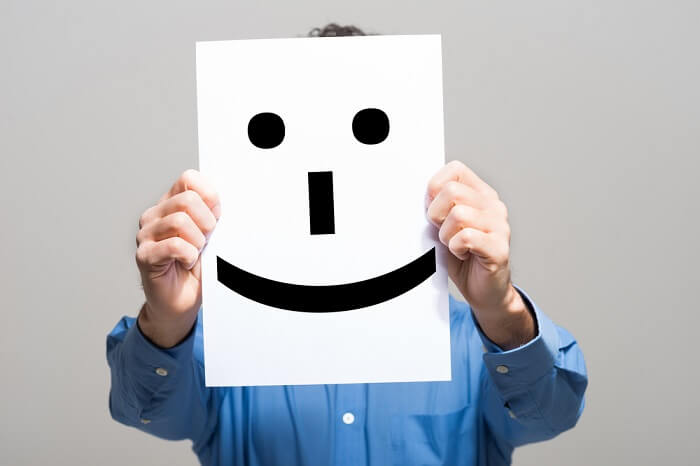 Man holding a smiling face emoticon
