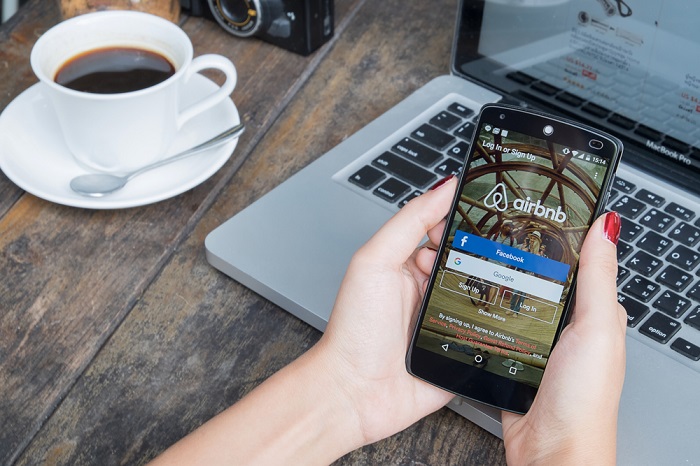 Airbnb-Smartphone und Kaffee