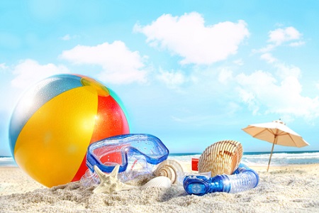 Strandball, Taucherbrille und Sonnenschirm am Strand